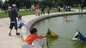 Lapset uittavat purjeveneitä pariisilaisen puiston vesialtaassa.