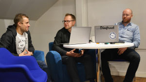 Johan Söderholm (till vänster) och Tomas Andersson (till höger) jobbar båda på Dimfrost medan Johnny Holmström driver Iotoi. De arbetar alla i samma lokal, i Cospace i Borgå. Tre män sitter vid ett bord med bärbara datorer framför sig.