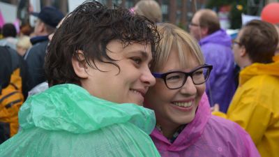 Silvia Modig och kollegan Aino-Kaisa Pekonen står i regnkläder och poserar mot en kamera till höger som inte syns.