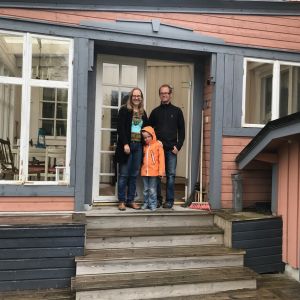 Anna, Arvid och Magnus Dahlbacka på trappan till deras hus. 