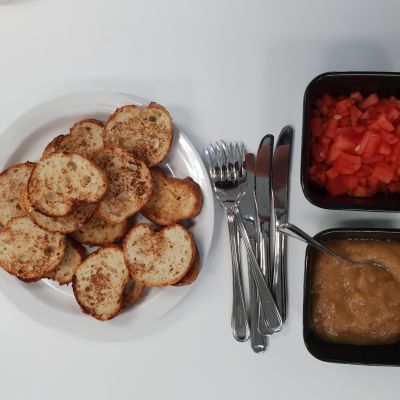 Köyhiä ritareita, hilloa ja paloiteltua vesimelonia. Kuvassa on myös haarukoita ja veitsiä.