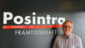 Peter Backman. En medelålders man står framför en svart vägg. På väggen står det med vit text Posintra framtidskraft.