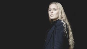 Carolina Wendelin utmanare Vegatoppen med låten George. kvinna i ljus långt hår står mot en svart bakgrund
