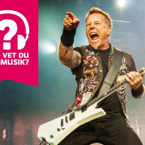 James Hetfield spelar elgitarr, gapar stort med munnen och pekar med ena handen ut mot publiken.