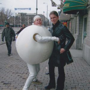 Palloksi pukeutunut nuorimies ja tämän nahkatakkiin pukeutunut kaveri poseeraavat kameralle hyväntuulisina keskellä jalkakäytävää.