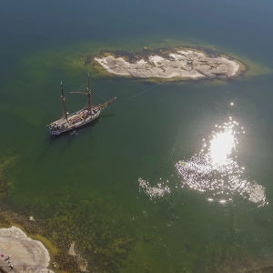 Ilmakuva Dalskär-saaresta ja purjealus kaljaasi Olgasta.