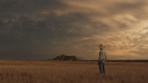 Chloé Zhao trivs bäst i öppna landskap. Här en bild ur genombrottsfilmen The Rider. en ensam cowboy står och tittar ut över ett öppet landskap.