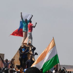 Mielenosoittajat heiluttavat lippuja kokoontuessaan mielenosoitukseen tukemaan Nigerin junttaa Niameyssä.