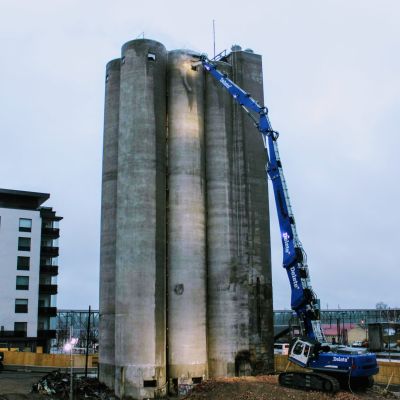 Purkukone työn touhussa. Purkukone yltää 43 metrisen siilojen huipulle, jossa se pikku hiljaa nakertaa betonia irti rakennuksesta.