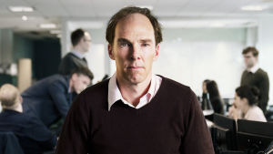 Benedict Cumberbatch gestaltar den politiska strategen Dominic Cummings, doldisen som numera fungerar som premiärminister Boris Johnsons främsta rådgivare. Benedict Cummings i rollen som den brittiska politiska strategen Dominic Cummings sitter på ett kontorsbord och ser rakt in i kameran.