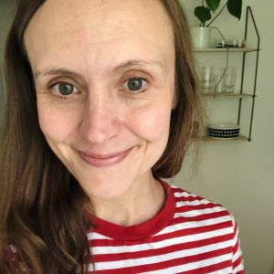 Monica Ålgars säger att en lösning på problemet är för vårdpersonal att bearbeta sina egna fördomar. Leende kvinna med brunt halvlångt hår. Bilden är tagen på nära håll och hon har på sig en rödvitrandig t-shirt.
