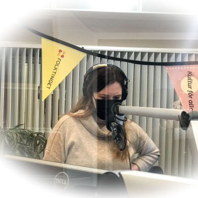 Milli Lindberg i radiostudio med munskydd.