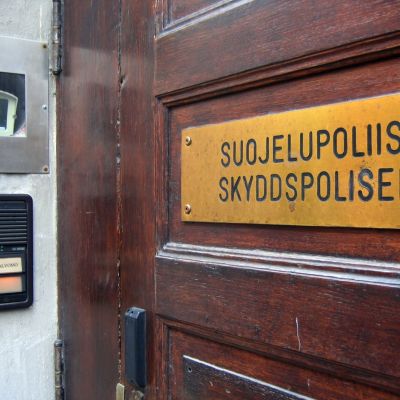Skylt på skyddspolisens dörr där det står: Suojelupoliisi - skyddspolisen.