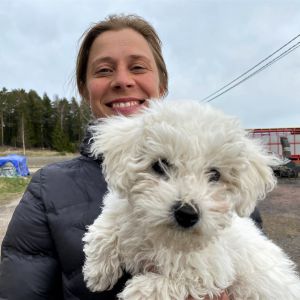 Mari Lindström med sin hund i famnen