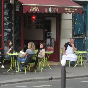 Asiakkaita kahvilan terassilla Pariisissa.