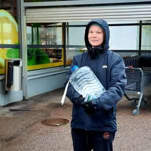 Taru Vuorela står utanför en butik i Korso och har inhandlat en behållare vatten.
