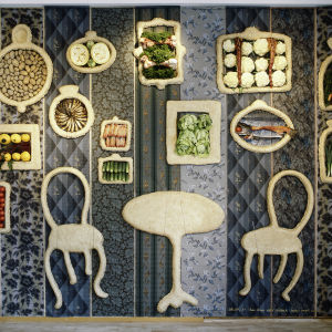 Salong +3 taiteilijaryhmän sinisävyinen vihanneksia ja sorkkia sisältävä installatio seinälle kiinnitettynä.