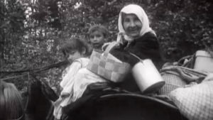 Mustalaisnainen ja lapsia hevoskärryissä maantiellä (1935)