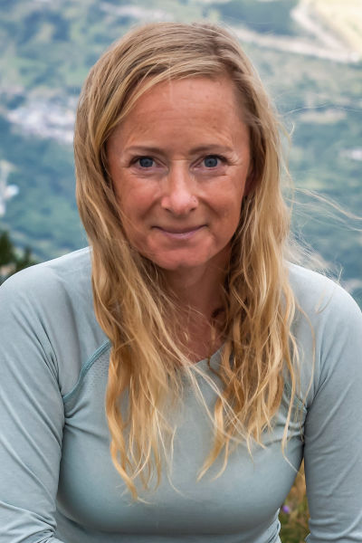 Alexandra småler rakt in i kameran. De franska alperna syns i bakgrunden.
