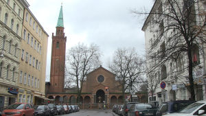 Moskén finns i anslutning till en kyrka. Gatuvy med kyrkan St. Johannis i Berlin.