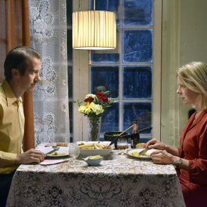 Näyttelijät Jussi Vatanen ja Alma Pöysti istuvat pöydän ääressä elokuvassa Kuolleet lehdet.