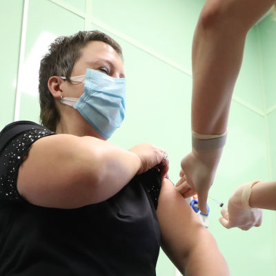 En person i Ryssland får coronavaccin, testförsök.