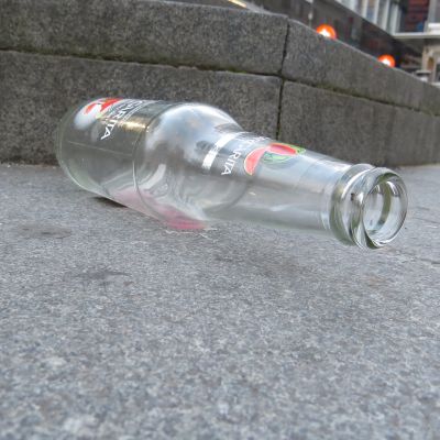Tyhjä pullo kävelykadulla.