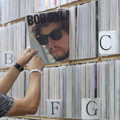En man tar fram en Bob Dylan-skiva från en hylla med massor av lp-skivor.