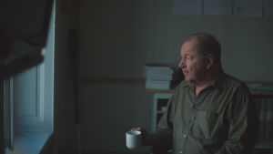 Den svenska regissören Roy Anderssons film "Om det oändliga" hade premiär tidigare i höst. Roy Andersson sitter med en kaffekopp och tittar ut genom ett fönster.