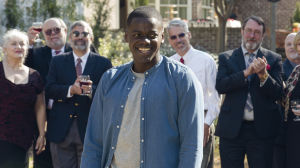 Daniel Kaluuya spelar Chris i Get Out. Chris (Daniel Kaluuya) står leende omringad av vita mänskor.