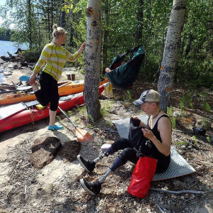 Kaisa, Ea och Antti slår läger vid strandkanten. Kaisa, Ea och Antti vilar efter en etapp i kajak.