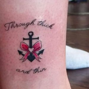 Kompistatuering. Tatuering som föreställer ett ankare med texten "Through thick and thin".
