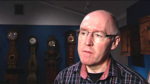 Intendenten Jouni Kuurne har hand om tillstånden för utförsel av kulturföremål. Man intervjuas i rum med gamla golvur i Nationalmuseet.
