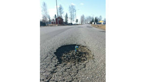 Vöråvägen för ett år sedan. En trip står i ett hål i Vöråvägen för att visa att hur stort hålet är.