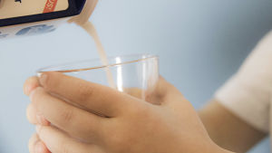 maitoa kaadetaan lasiin ja tekstigrafiikka, jossa väite maidon terveellisyydestä