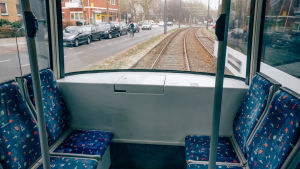raitiovaunun tyhjiä penkkejä ja näkymä takaikunasta ulos