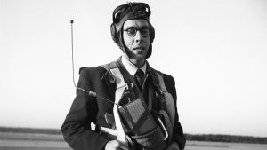 Usko Santavuori laskuvarjohyppääjän varusteissa mikrofoni rintaan kiinnitettynä (1950).