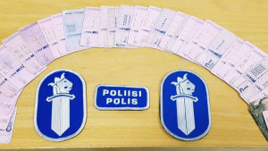 Polisen radade upp körkorten de beslagtagit. Rad av körkort som beslagtagits av polisen och i mitten polisens emblem.