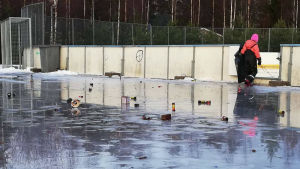 Folk hade lämnat mycket skräp efter sig. Isplan med mycket skräp. En flicka plockar upp skräpet i en sopsäck.