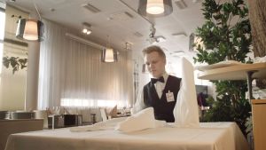 Johan Lindström drömmer om en framtid som hovmästare eller sommelier.. Johan Lindström vid ett dukat bord.