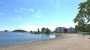 Regatta Spa på Fabriksudden. En sandstrand och en vit byggnad i bakgrunden.