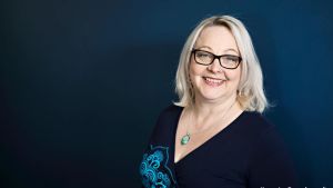 Erika Kähärä på servicefacket Pam är förvånad över att det finns chefer som vågar ta risken att många anställda och företagets kunder kan bli sjuka. En kvinna med blont hår och glasögon. Står framför en mörk vägg.