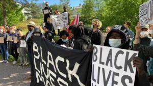 I juni samlades en grupp demonstranter utanför polishuset i Böle i Helsingfors. Demonstranter med Black Lives Matter-plakat.