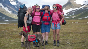 hela kungsledenvandringsgruppen håller om varandra med stora berg med fjäll i bakgrunden