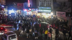 laaja väkijoukko Istanbulin kadulla liikkeiden edessä