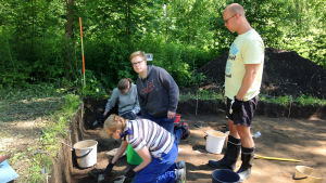 Heurekan yleisökaivauksilla voi kokeilla millaista on arkeologin työ. Vantaan Jokiniemen yleisökaivauksille osallistujat kaapivat maata, arkeologian opiskelija katselee