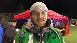 Redan innan matchen började var Kristoffer Smeds övertygad om att Akilles vinner. En man i grön jacka står utomhus på ett sportevenemang. Han ler och tittar in i kameran.