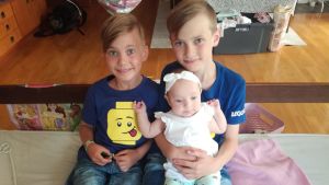 Familjen Lundström består nu av mamma, pappa och sju barn. Lilla Ada sitter här tillsammans med bröderna Albin och Elliot. Två bröder med sin lillasyster i famnen.