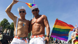 Vesa Uusitalo och Aleksi Tiiro. Vesa Uusitalo och Aleksi Tiiro klädda i sjömansmössor, vita byxor och bar överkropp på Helsingfors pride 2016.