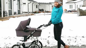 Hilla Lamminpää on tuore äiti nainen työntää lumisessa pihapiirissä vauvanvaunuja